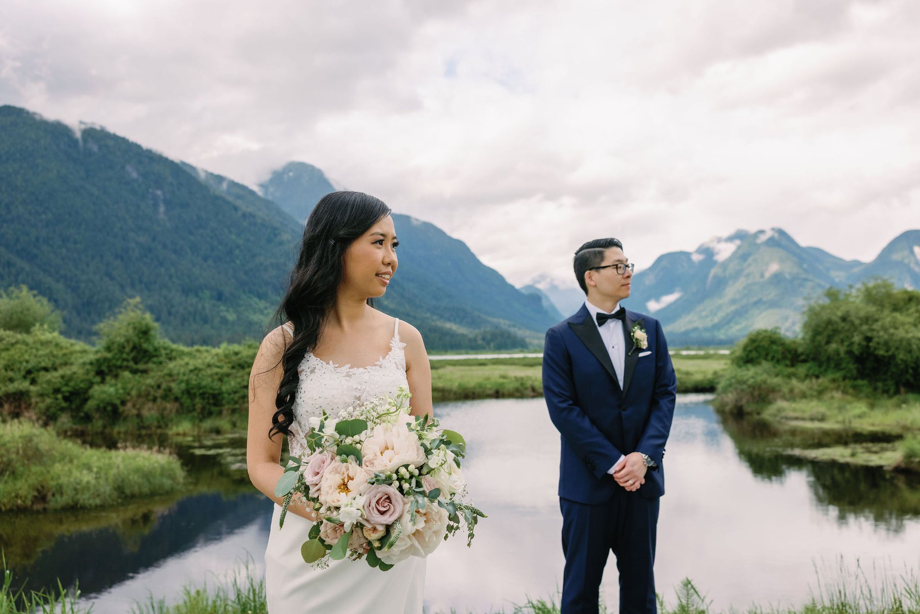Bride and groom looking at each other beside the marsh