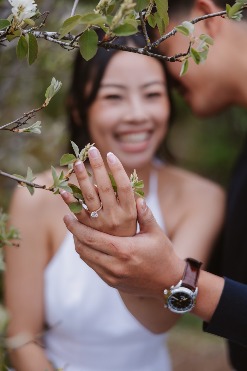 Aneeta holding a spring blossom beside her engagement ring