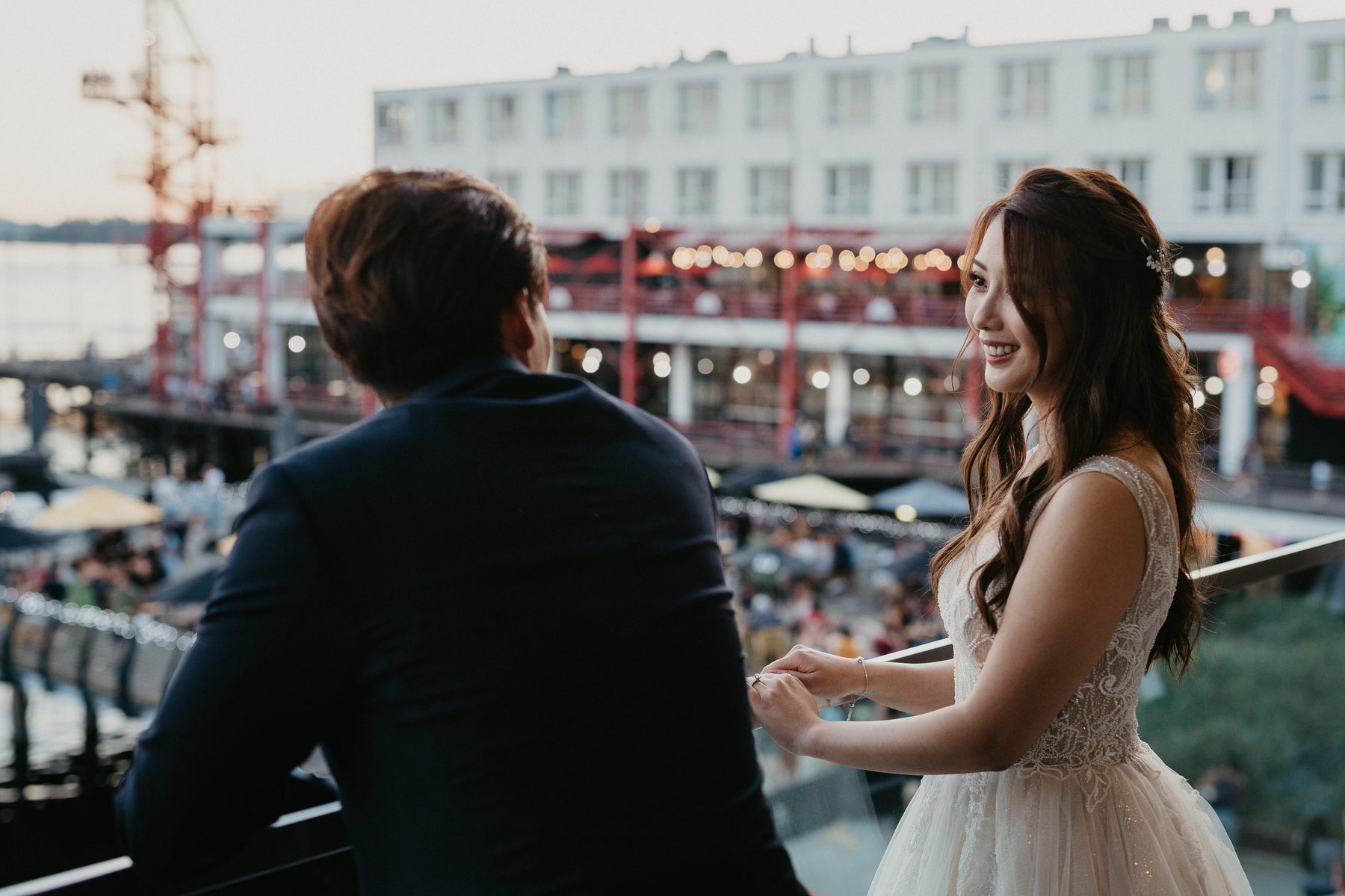 Couple at golden hour on the North Vancouver waterfront with the pier behind them