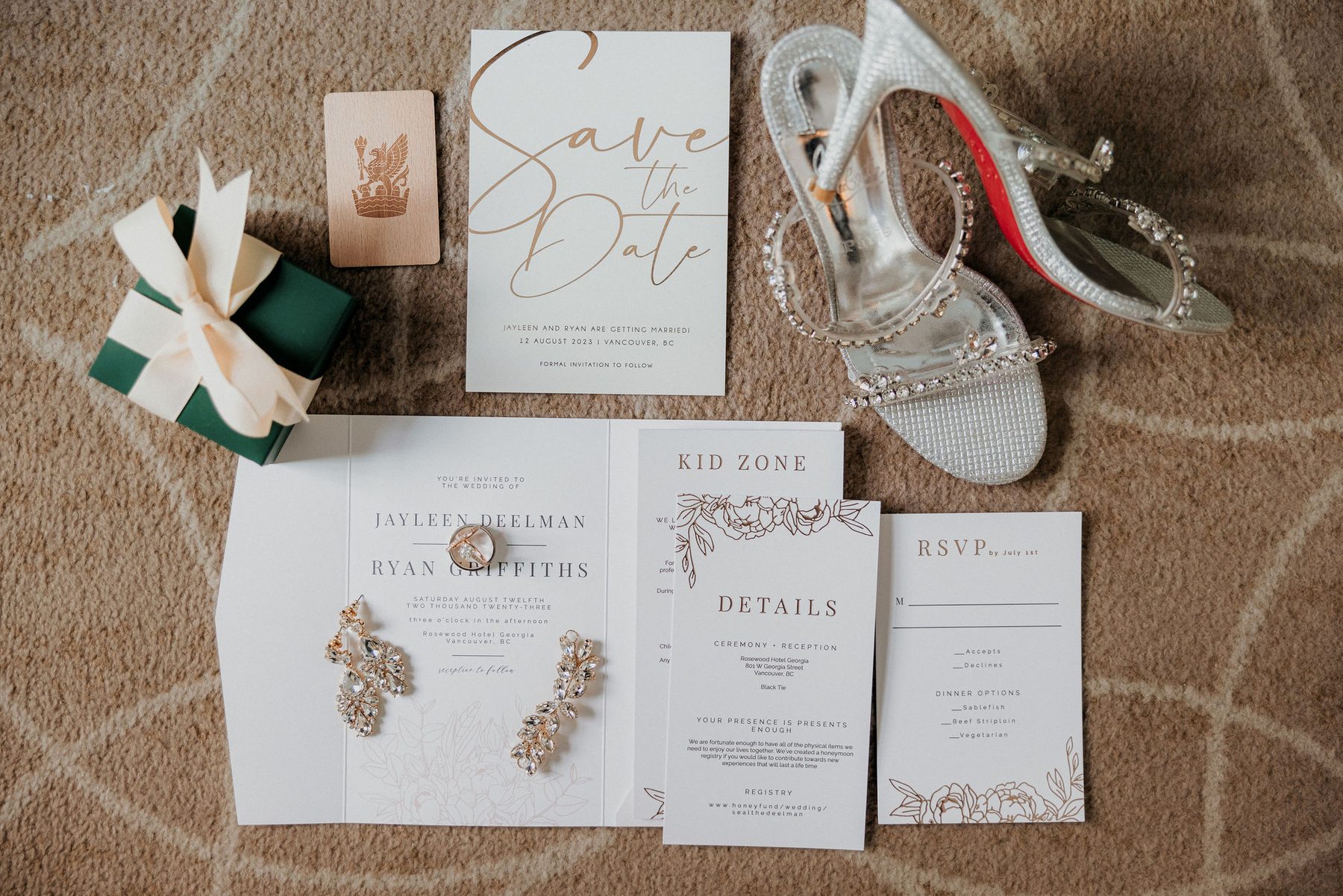Gold-foil wedding invitation suite laid out with the bride's heels and jewellery