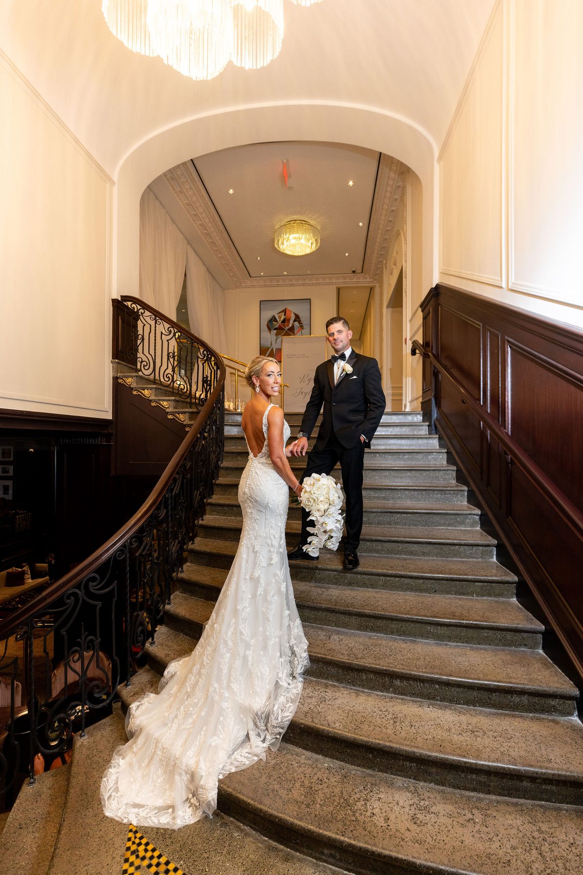 Bride in a lace gown descending the grand staircase at the Fairmont Hotel Vancouver