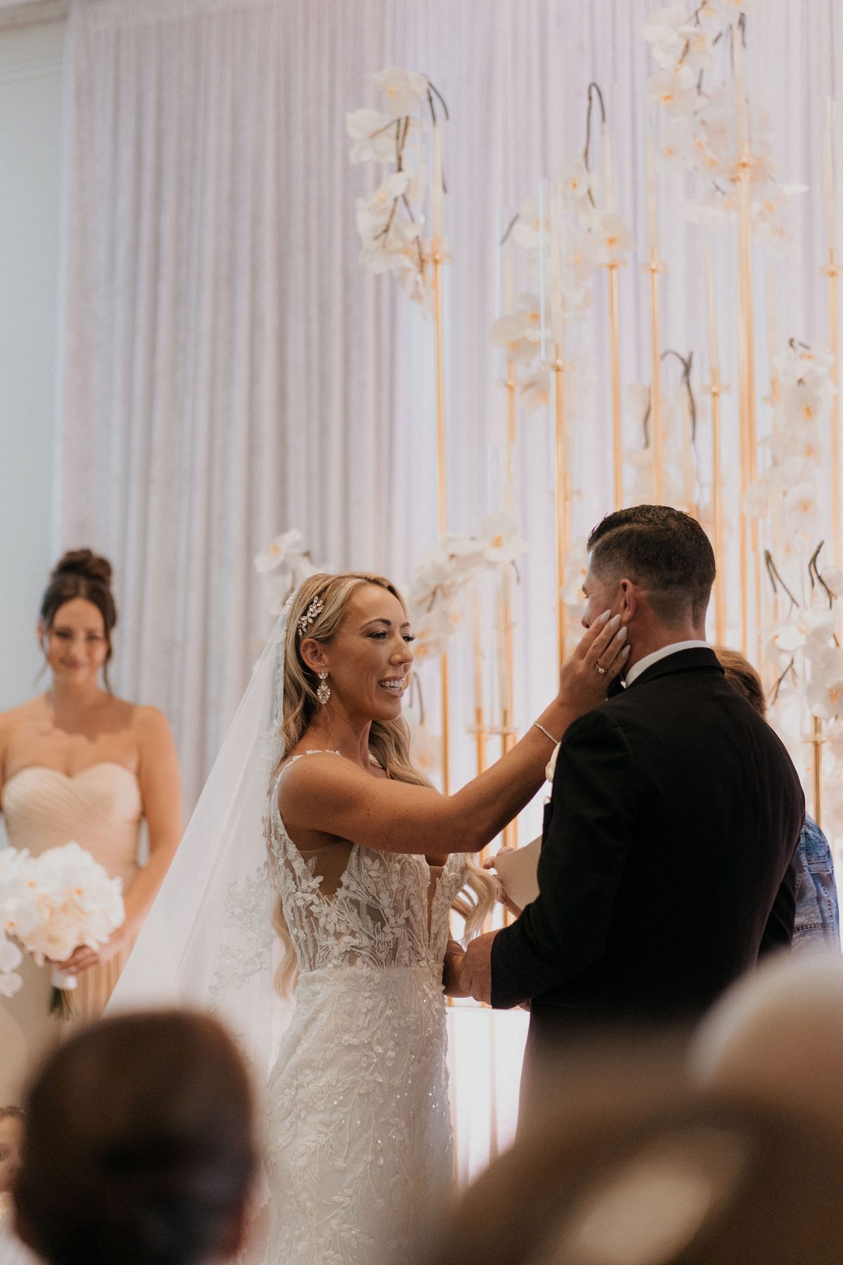 Bride resting a hand on her groom's face during the vows
