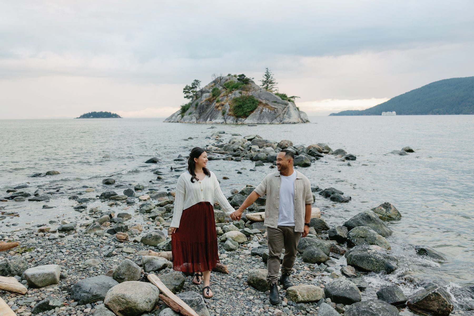 Couple standing on the rocky shore at Whytecliff Park with Whyte Islet behind them