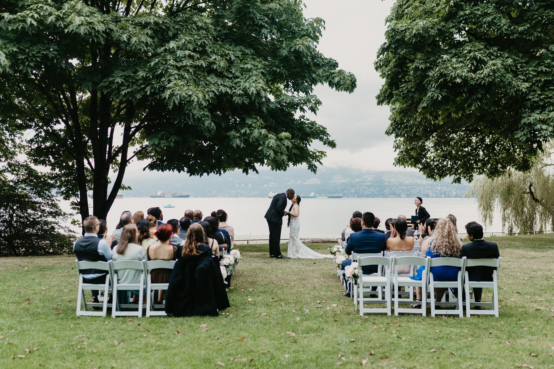 Lakeside ceremony with guests seated under the trees