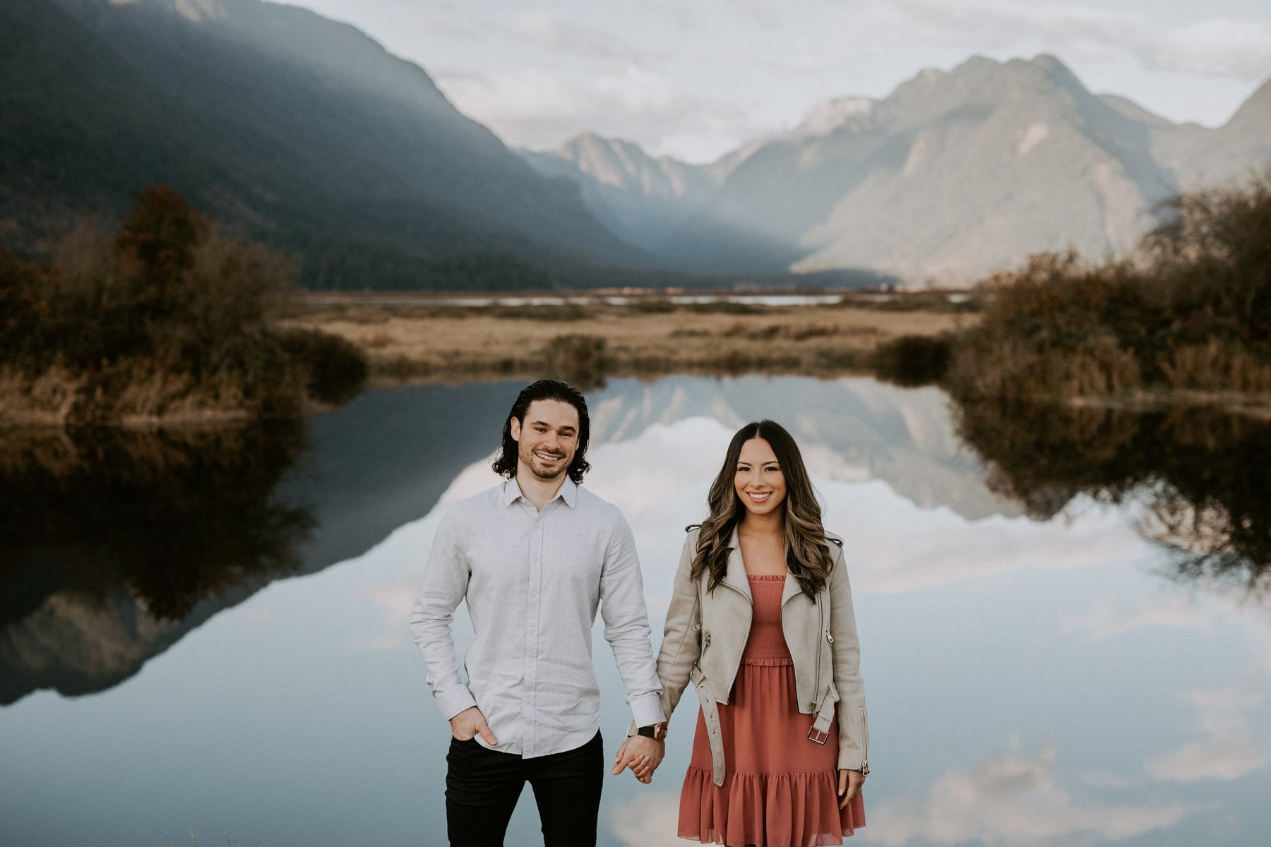 Couple at Pitt Lake with the mountains mirrored behind them